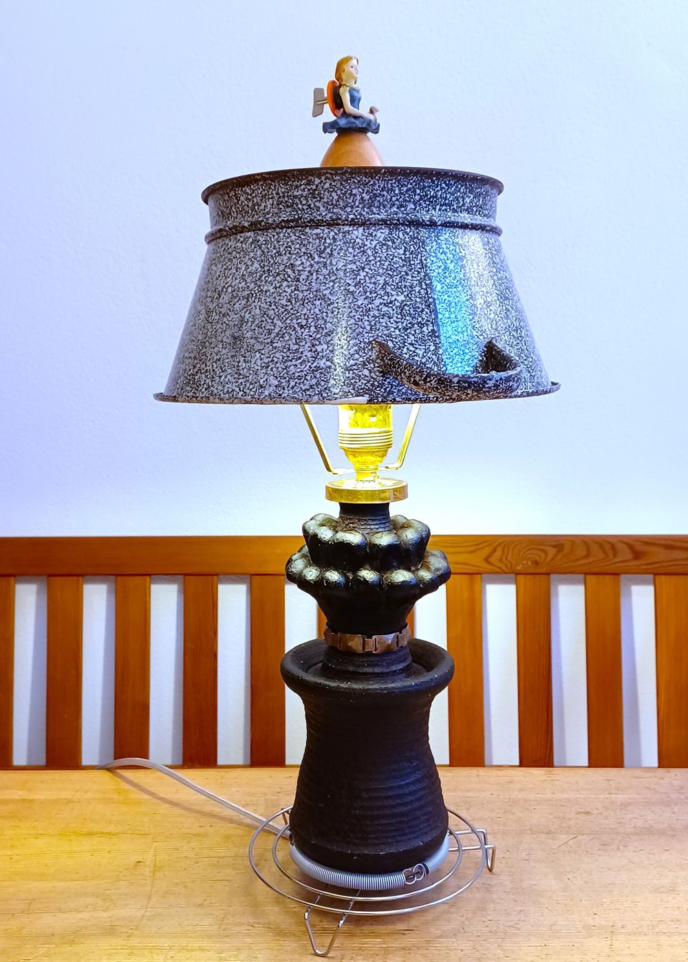 Dekorative Tischlampe mit grauem Schirm und schwarzem Fuß auf einem Holztisch