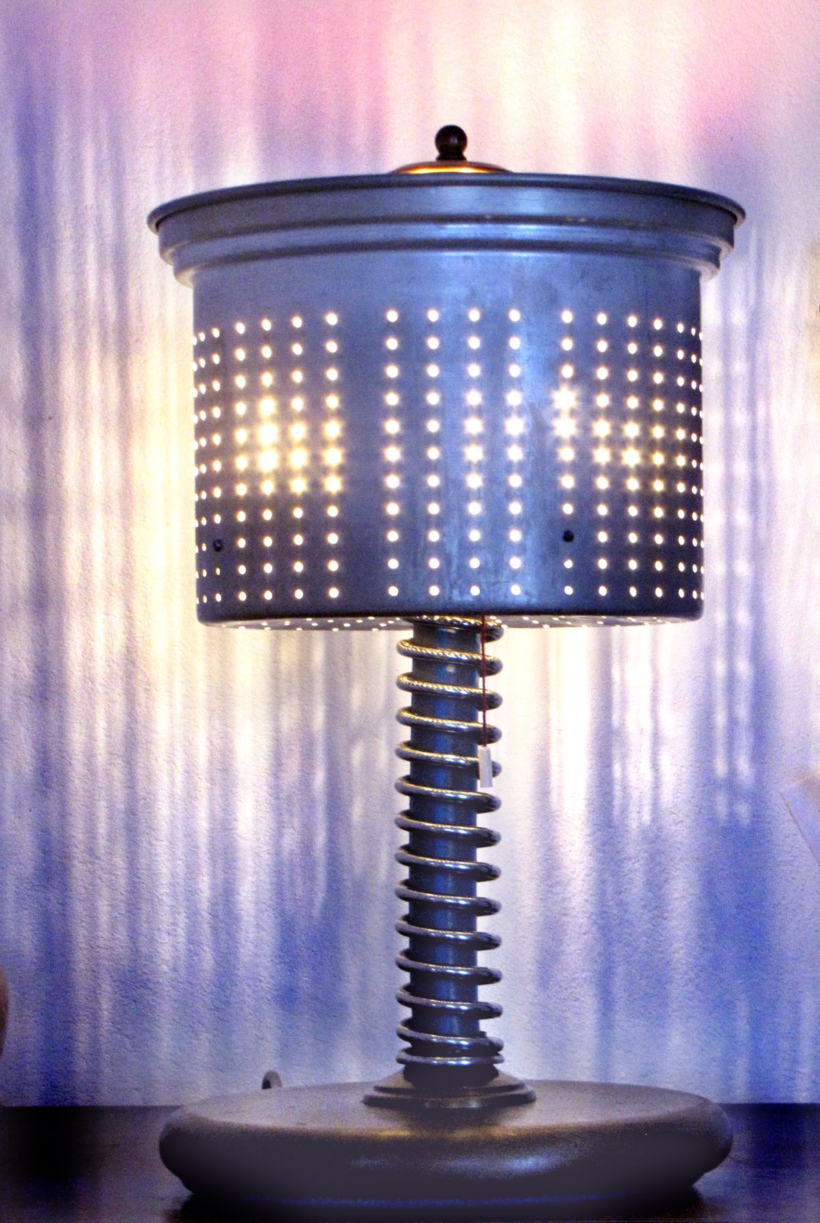 Moderne Tischleuchte mit perforiertem blauem Schirm und spiralförmigem Stiel auf rundem Fuß
