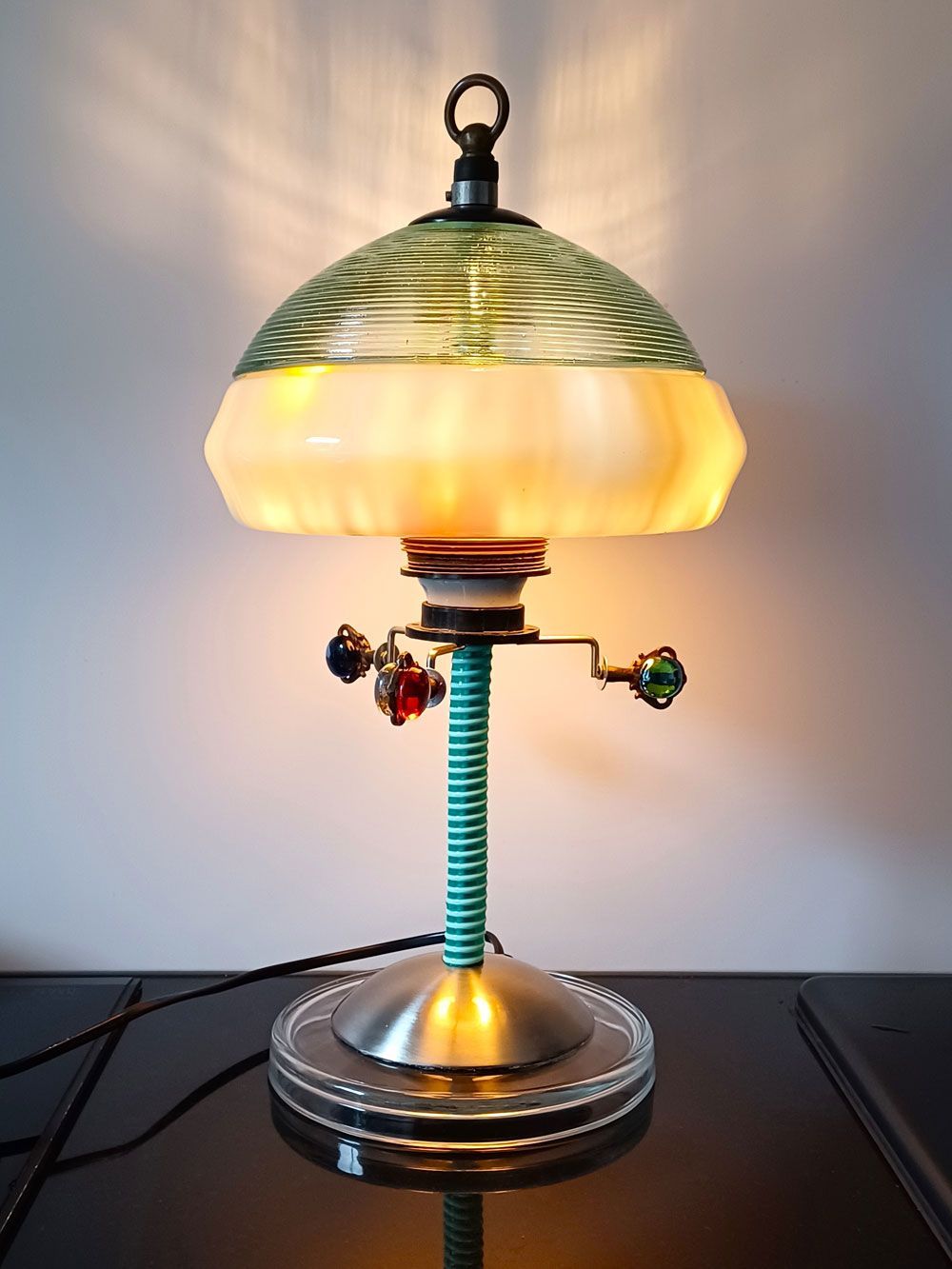 Vintage-Schreibtischlampe mit mattiertem gelbem Glasschirm und Chromfuß, die ein warmes Licht vor einer schlichten Wand ausstrahlt