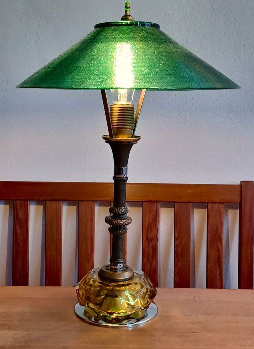 Antike Tischlampe mit grünem Glasschirm und Messingfuß auf einem Holztisch