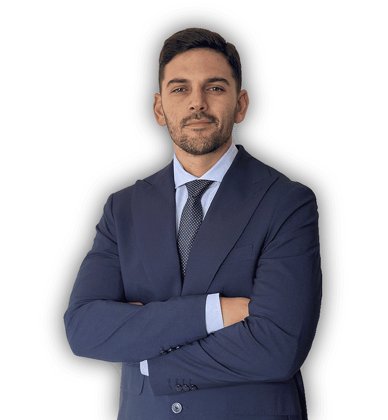 Hombre con traje azul marino, con los brazos cruzados y sonriendo.