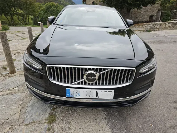 Un coche Volvo negro está aparcado al costado de la carretera.