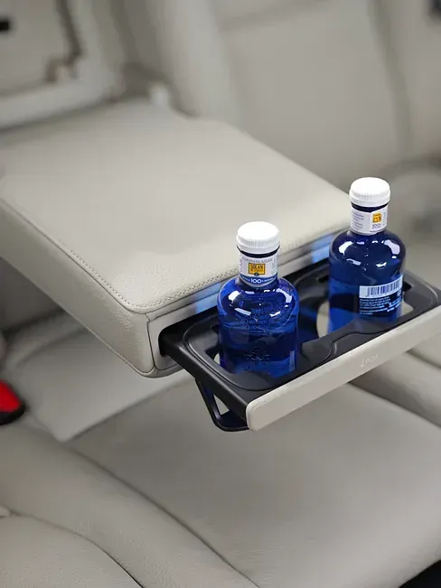 Hay dos botellas de agua en una bandeja en el asiento trasero de un automóvil.