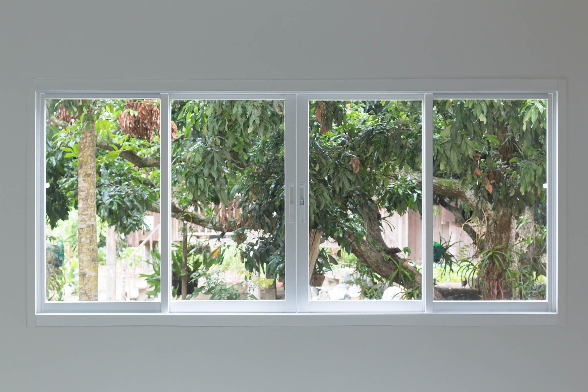 Deux fenêtres coulissantes ouvertes menant sur un jardin
