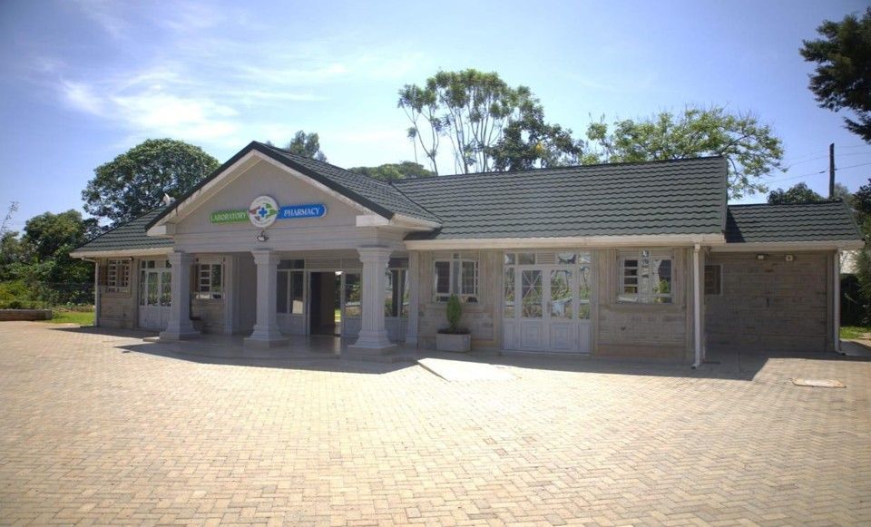 A light brick building with pillars, a green roof, and a sign that reads "Garden Family".
