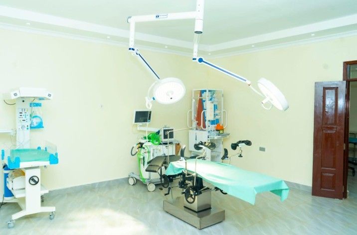 Operating room with surgical lights, equipment, and an examination table.