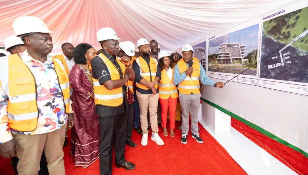 A group of people wearing hard hats and safety vests are standing in front of a wall.