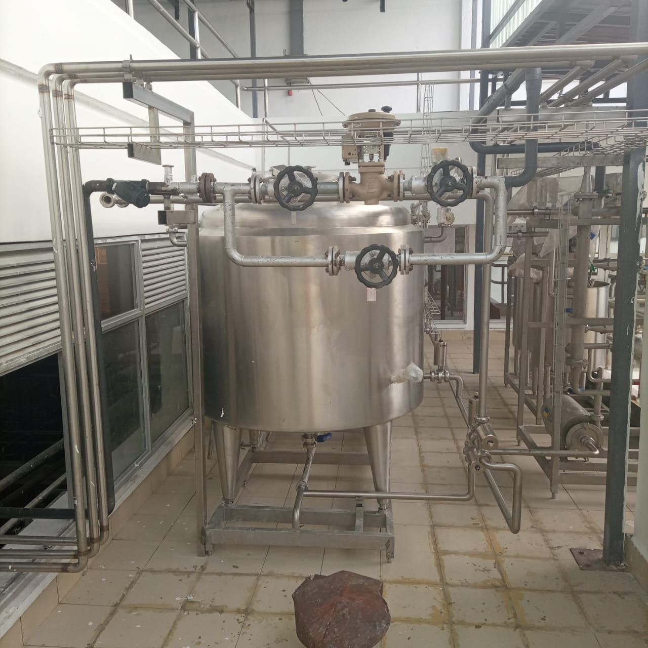 A large stainless steel tank with wheels on top of it