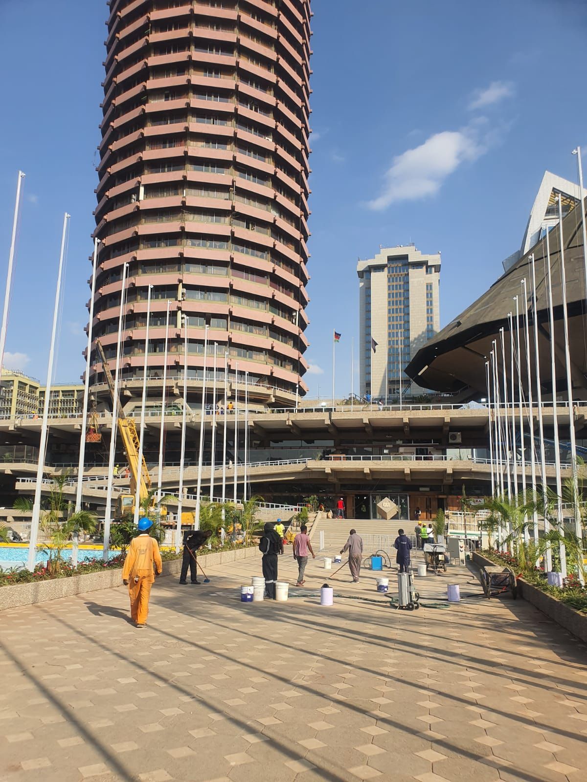 A group of people are walking in front of a tall building