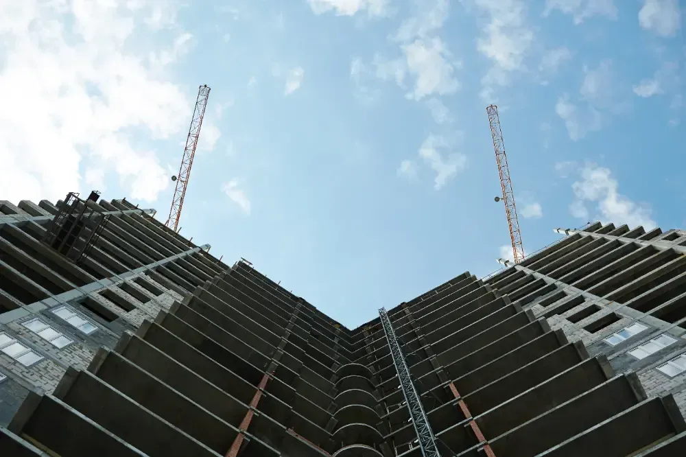 Looking up at a building under construction with a blue sky in the background