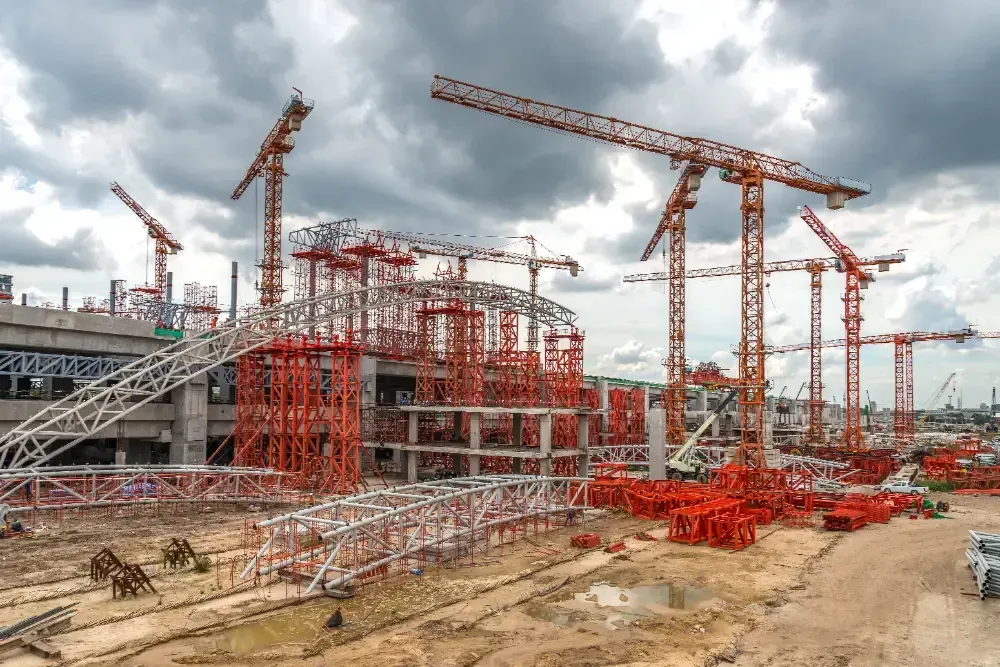 A large construction site with a lot of cranes and scaffolding.