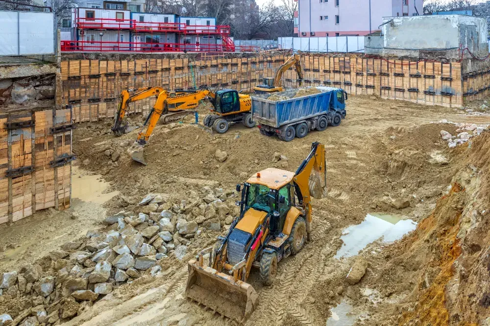 A group of construction vehicles are working on a construction site.