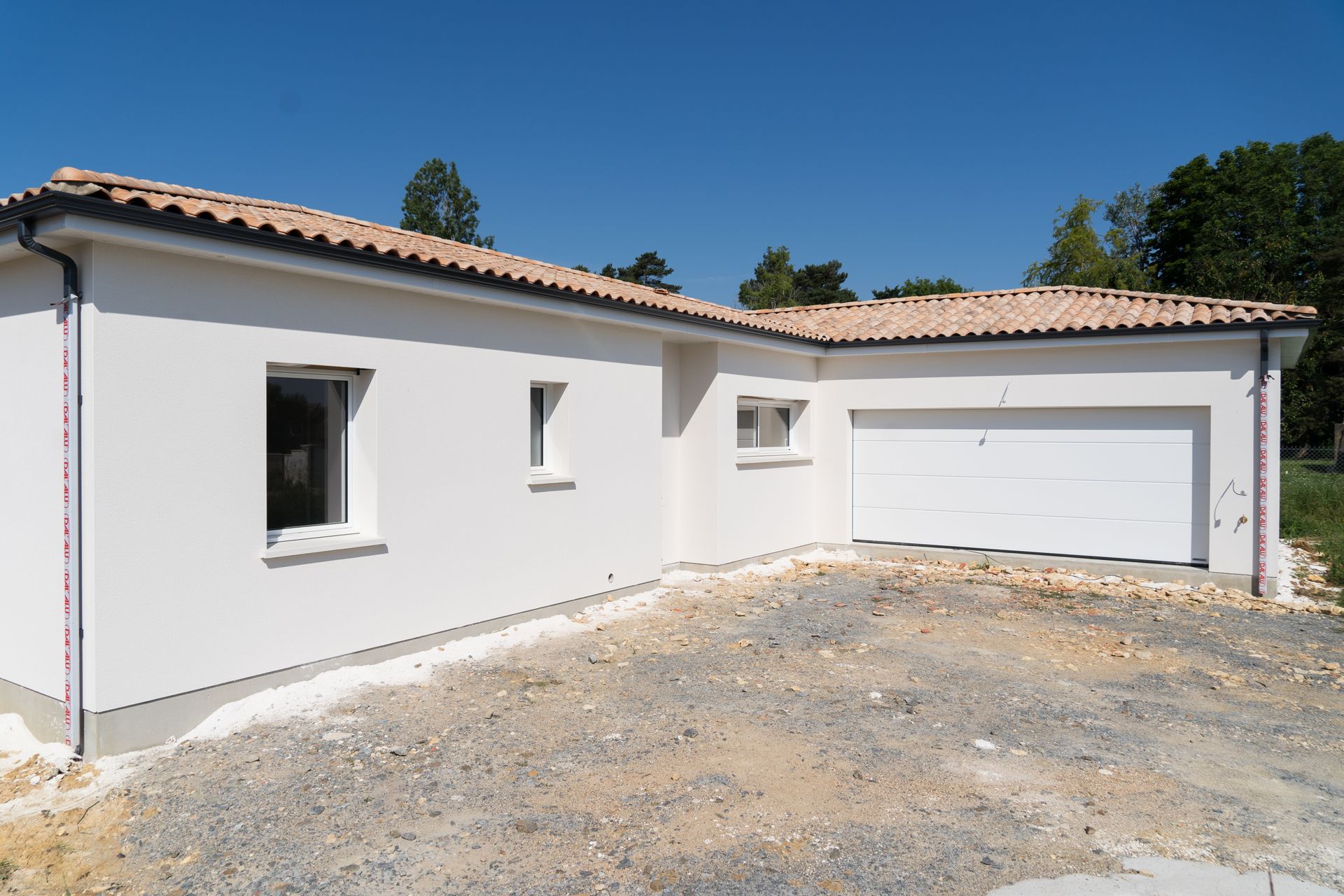 Maison avec un garage à la façade blanche