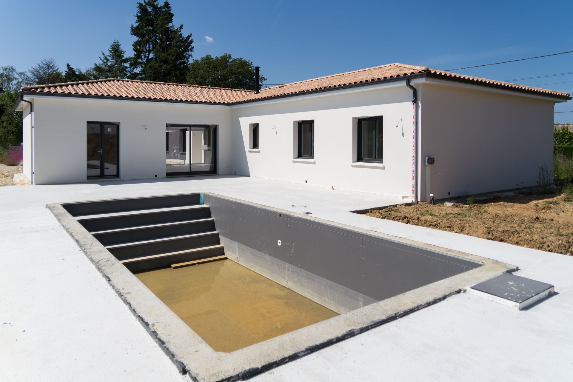 Maison au crépi blanc avec piscine creusée vide