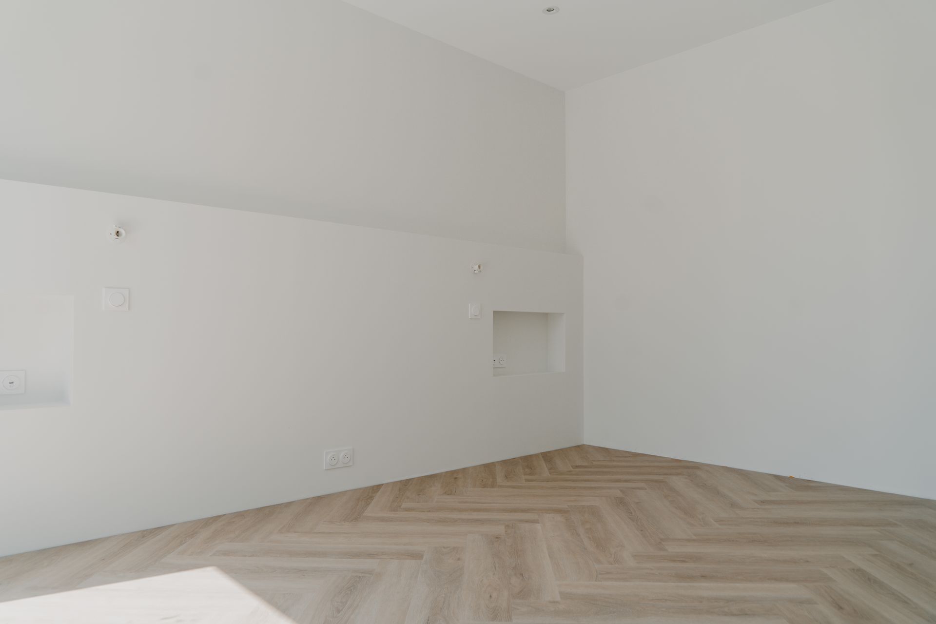 Pièce aux murs blancs et au sol en parquet