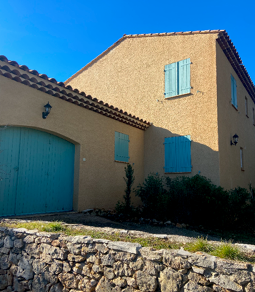 Façade de maison avec des volets et une porte de garage bleus fermés