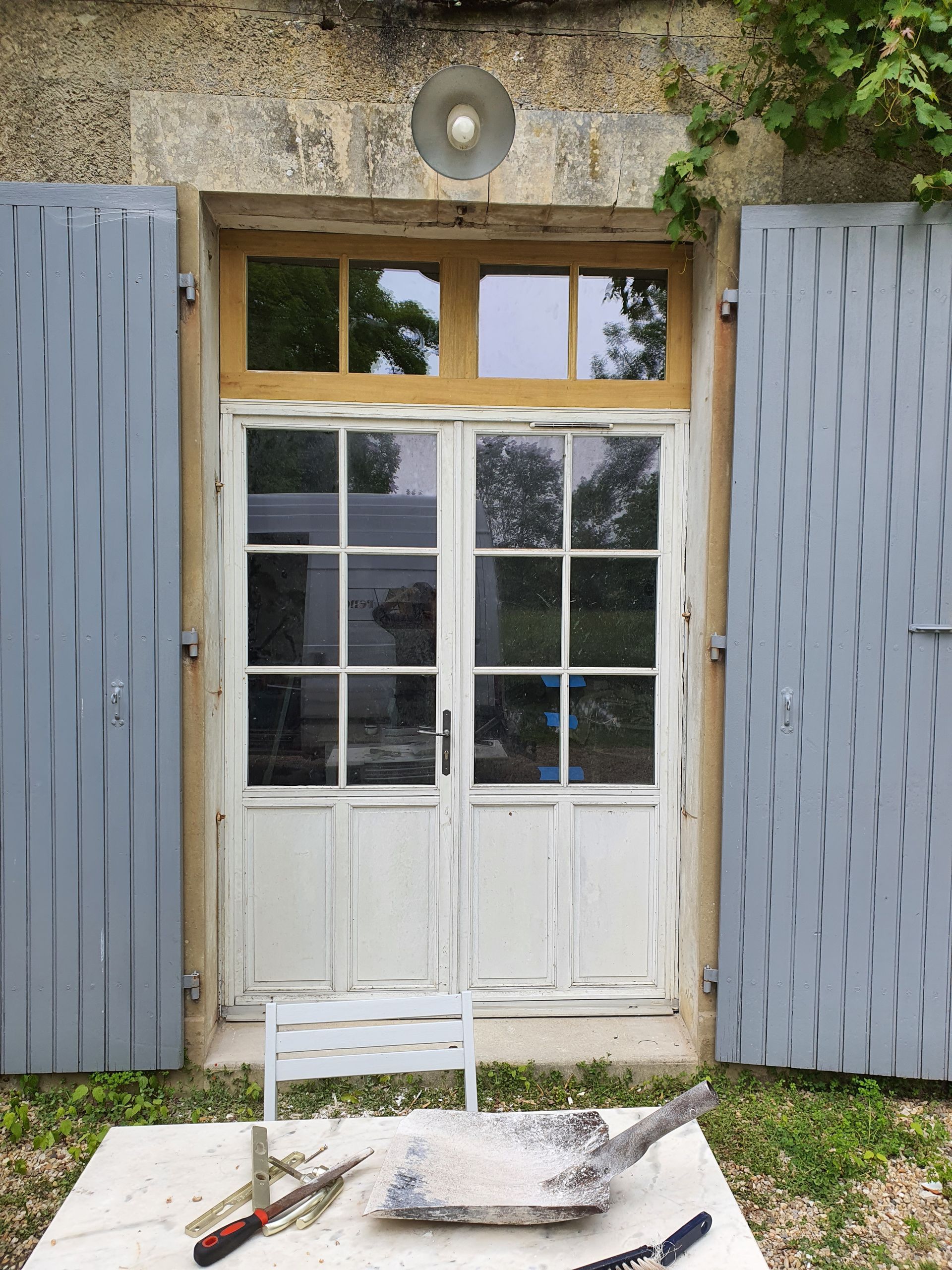 Porte d'entrée blanche avec des volets gris