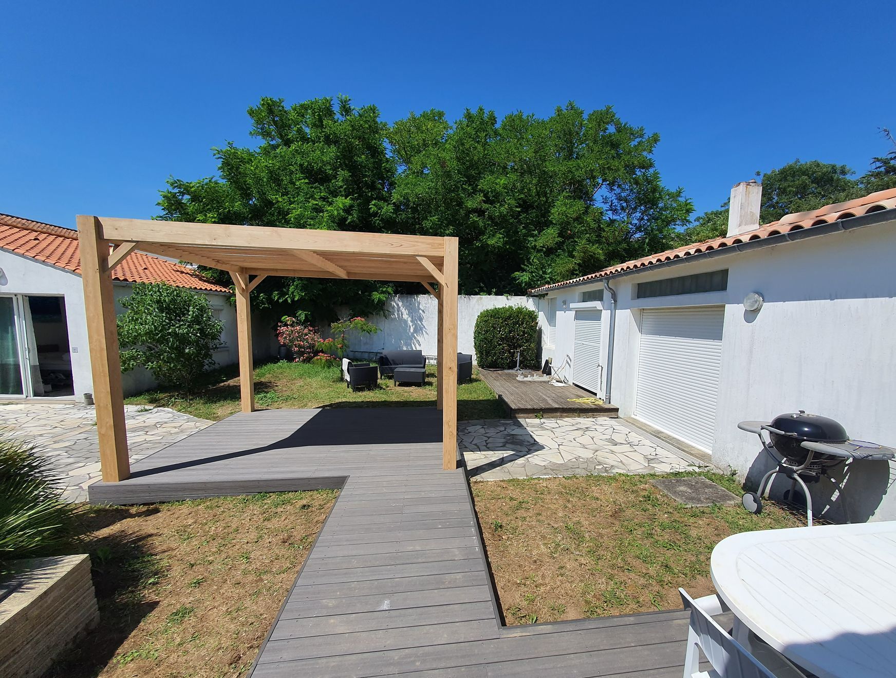 Pergola et terrasse en bois avec un barbecue à droite