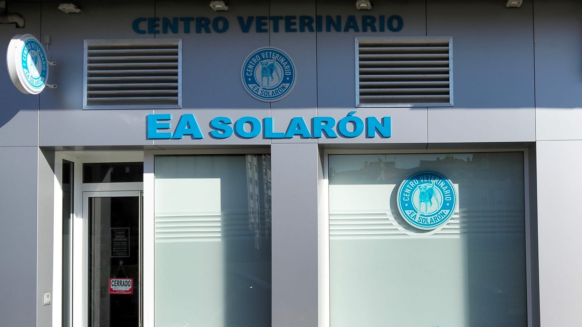Fachada de clínica veterinaria con letrero azul “EA SOLARÓN” y “CENTRO VETERINARIO” sobre la entrada.