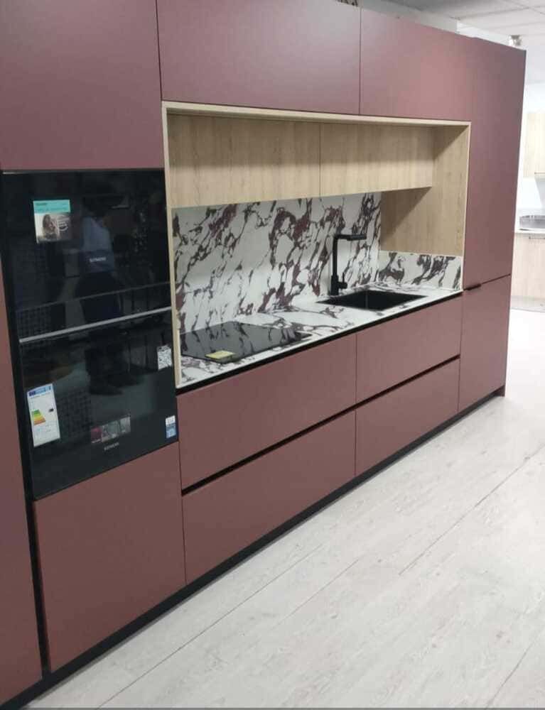 Una cocina con gabinetes marrones y un horno negro.