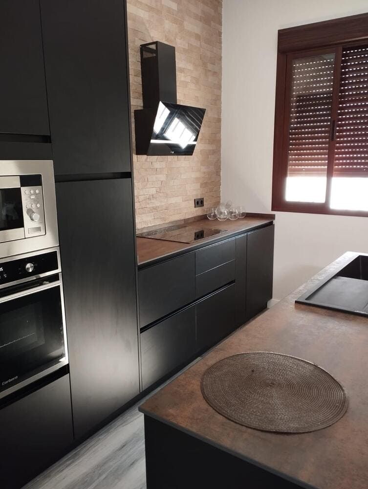 Una cocina con gabinetes negros y un horno de estufa.