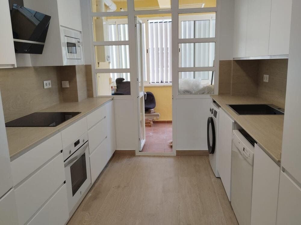 Una cocina con gabinetes blancos y un horno de estufa.