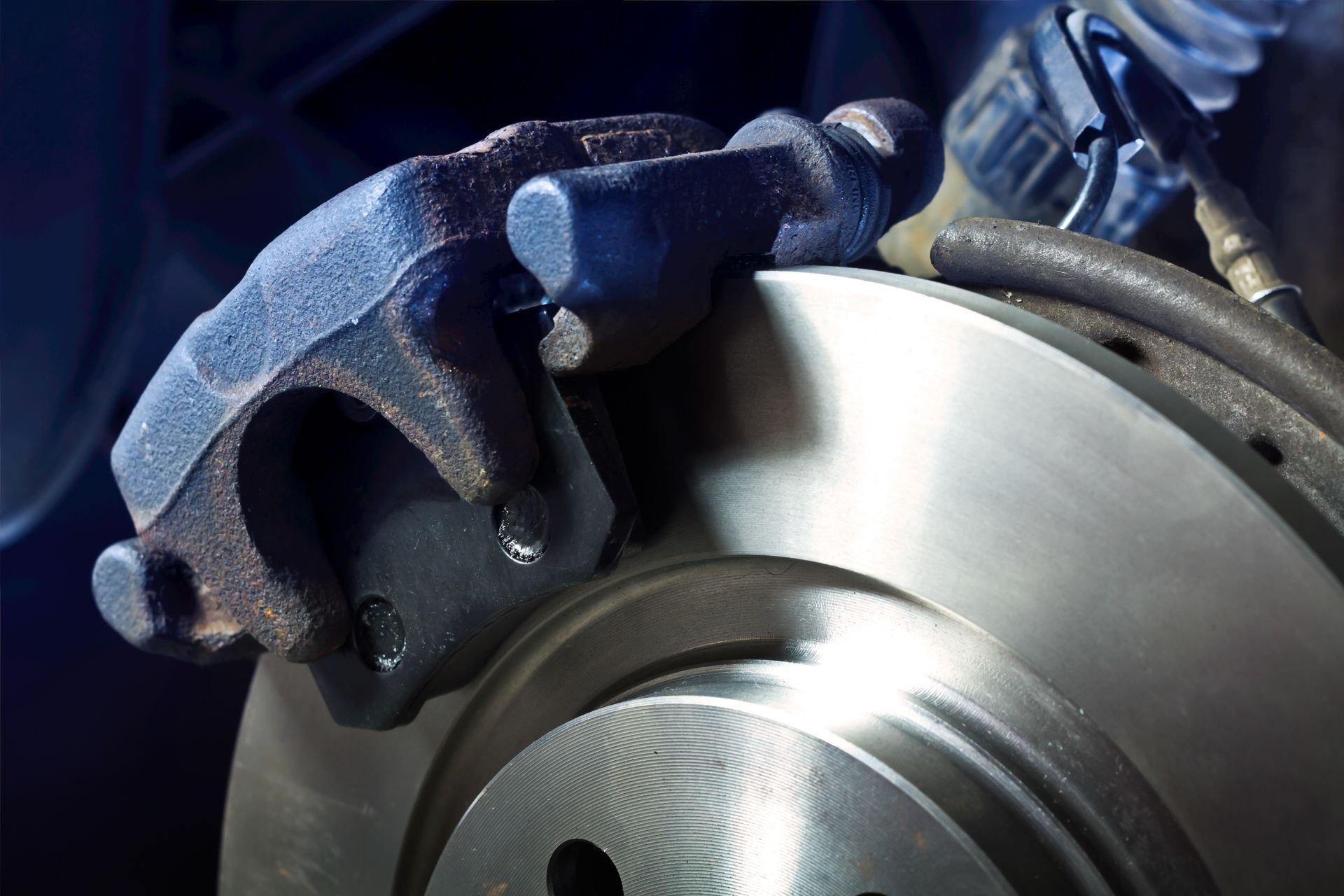 Étrier et disque de frein d'un véhicule, dans un environnement d'atelier.