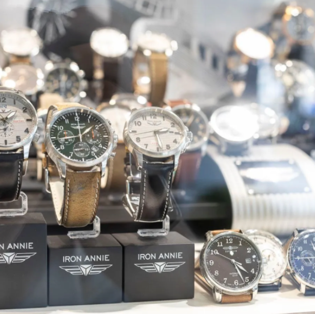 Vitrine mit Iron Annie-Uhren auf schwarzen Ständern; Lederarmbänder; verschiedene Zifferblätter.