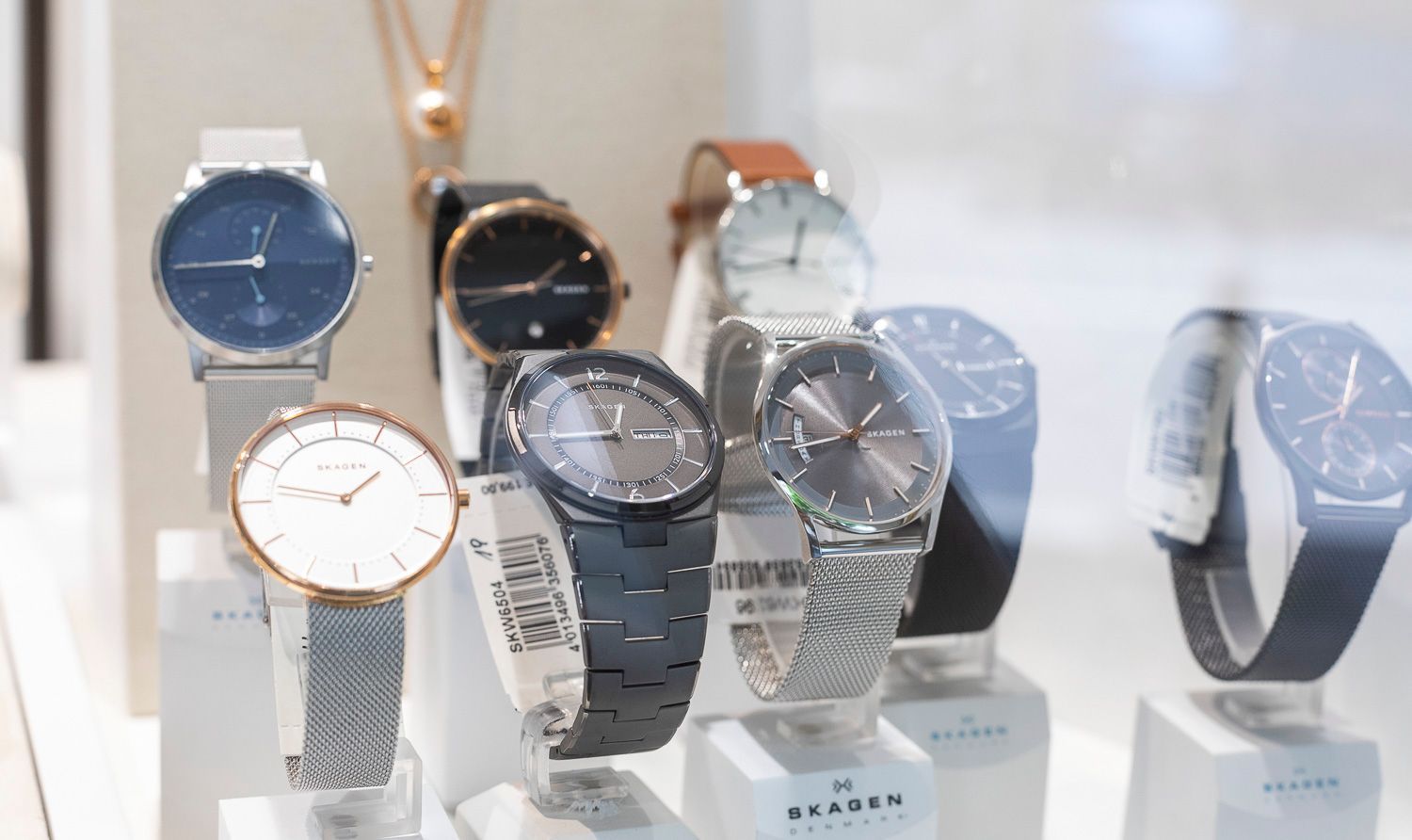 Uhren in einer Glasvitrine. Verschiedene Stile und Farben, darunter Silber, Schwarz und Braun.