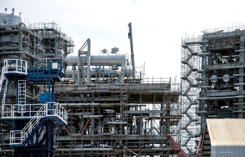 Gebäude im Umbau, außen ein Gerüst, bewölkter Himmel.