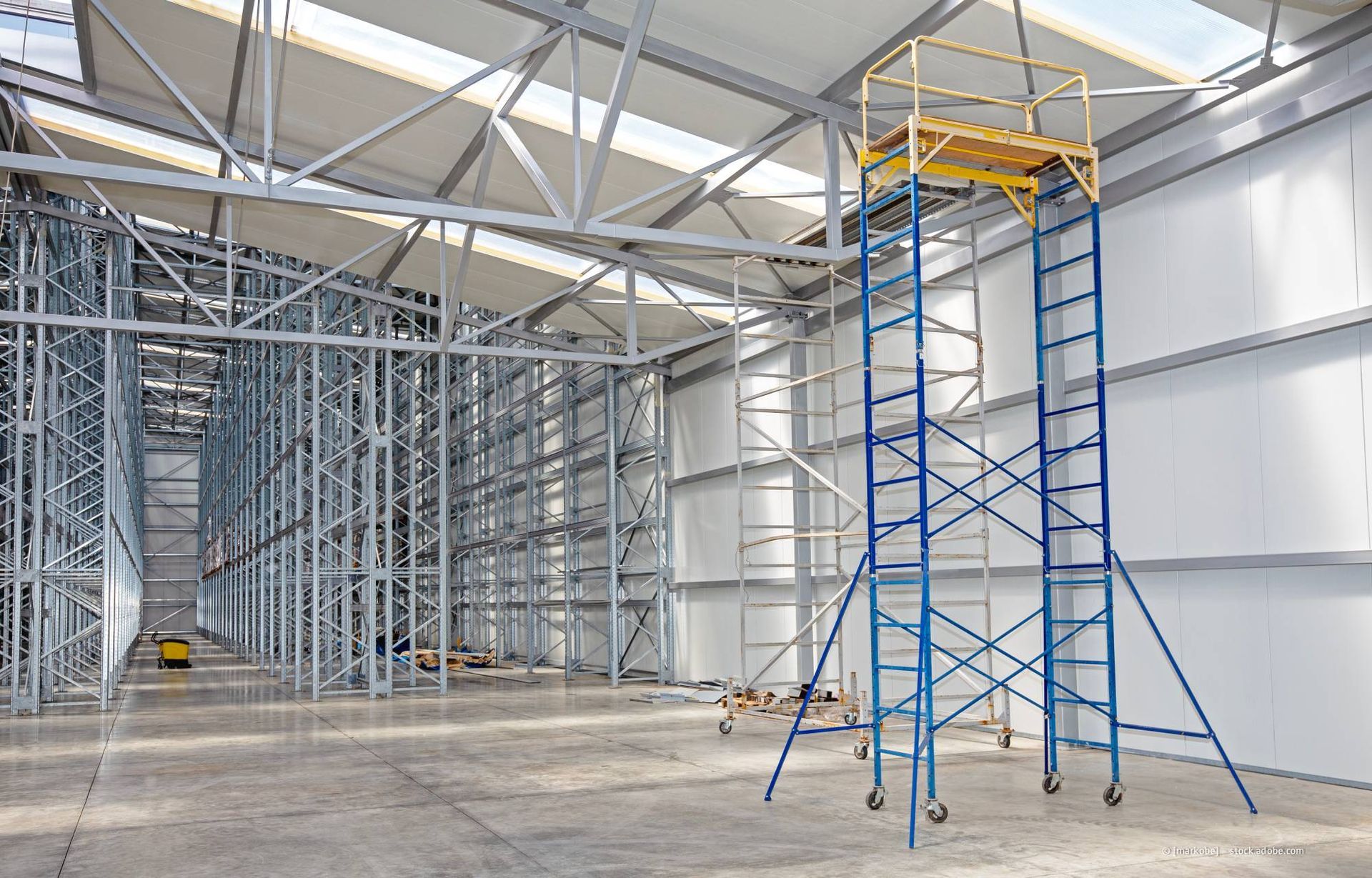 Die Stahlrahmenkonstruktion des Lagerhauses befindet sich im Bau und ist mit einem hohen, fahrbaren Gerüst ausgestattet.