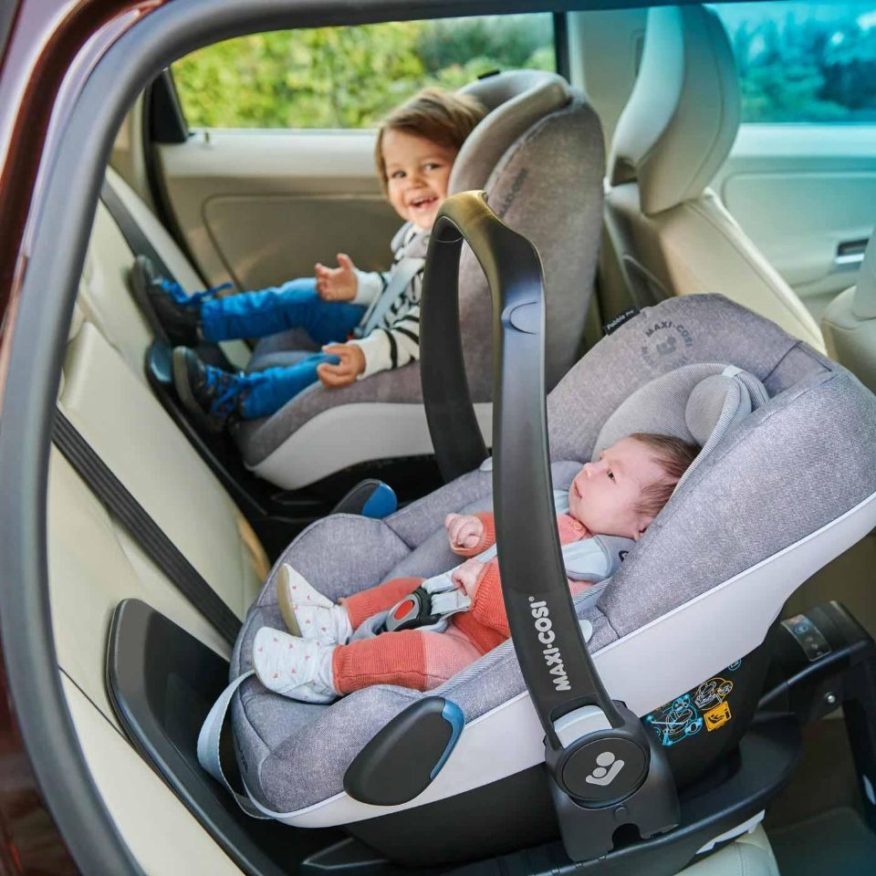 zwei Kinder in Kindersitzen