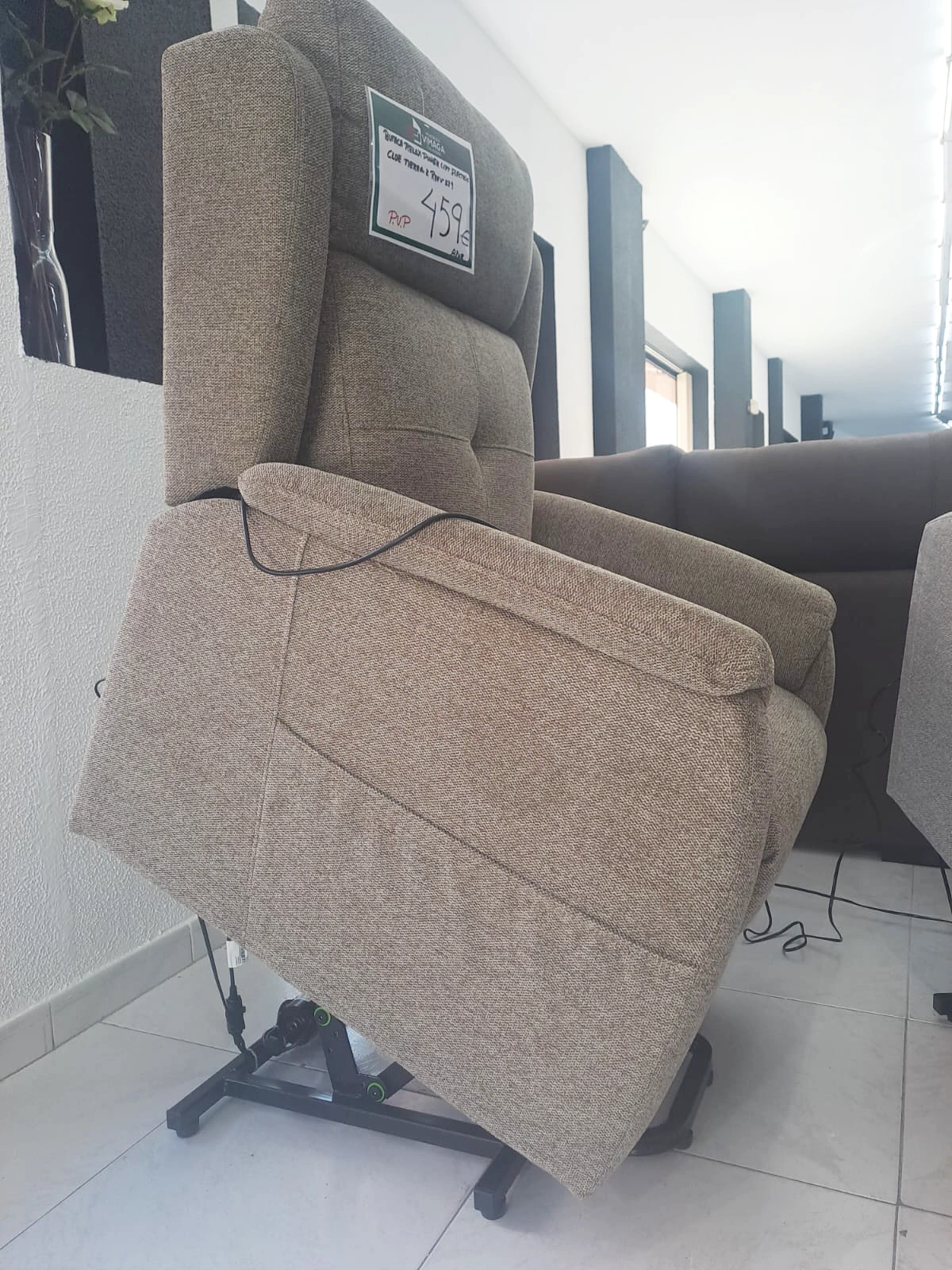 Un sillón reclinable está sentado en una sala de estar al lado de un sofá.