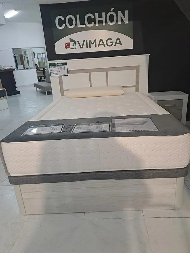 Una cama en una tienda con un cartel que dice colchon vimaga