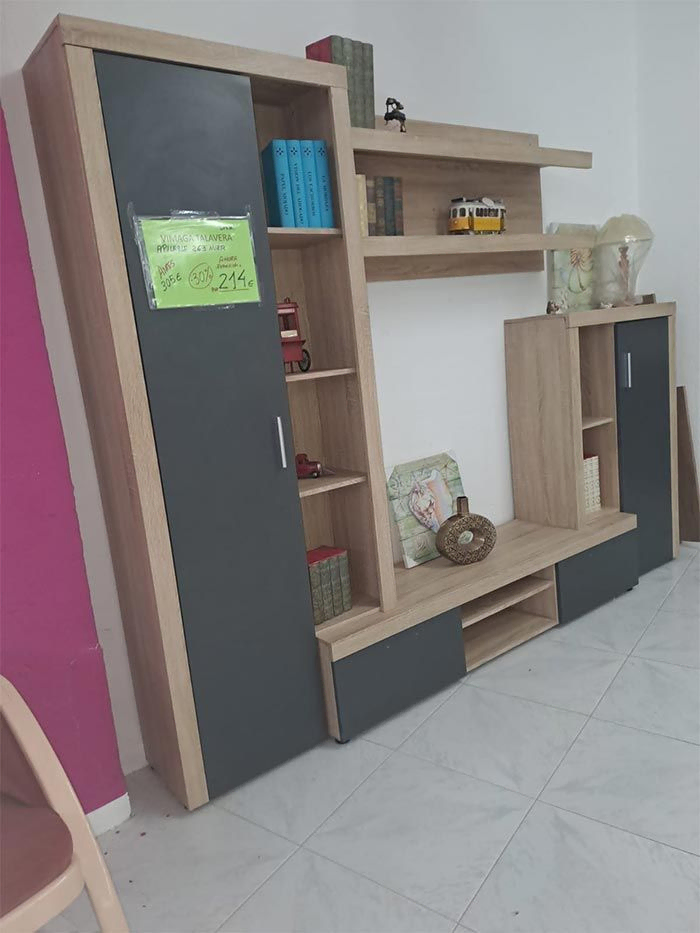 Una sala de estar con un centro de entretenimiento de madera y una pared rosa.