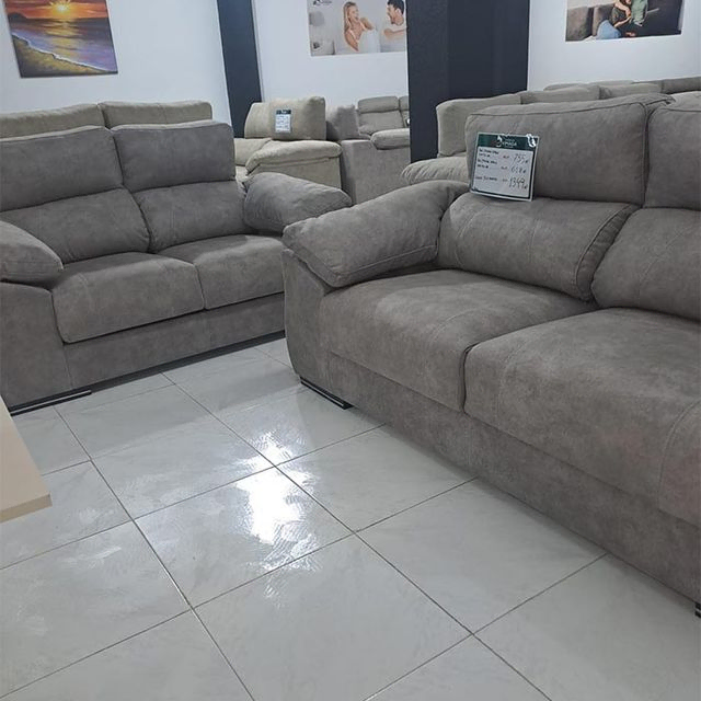 Una sala de estar llena de muchos sofás grises.