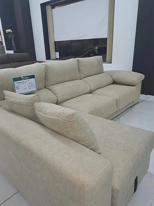 Un sofá seccional de color beige está ubicado en una sala de estar.