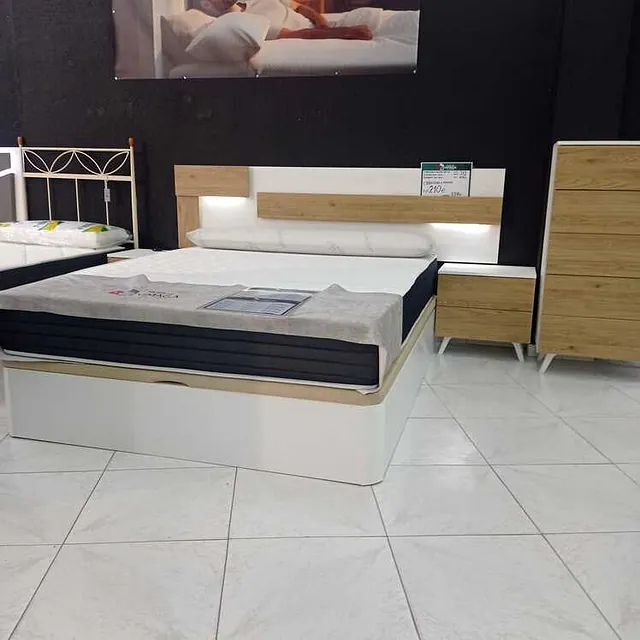 Un dormitorio con una cama y un cuadro en la pared.