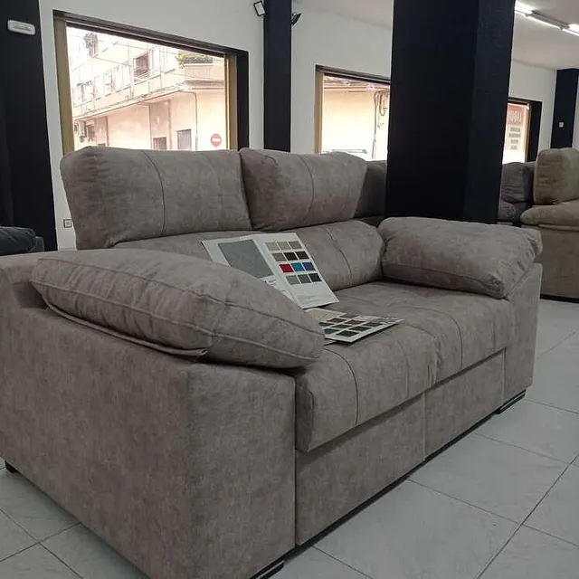 Un sofá con un libro encima en una habitación.