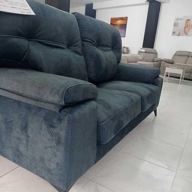 Un sofá azul está sentado en una sala de estar.