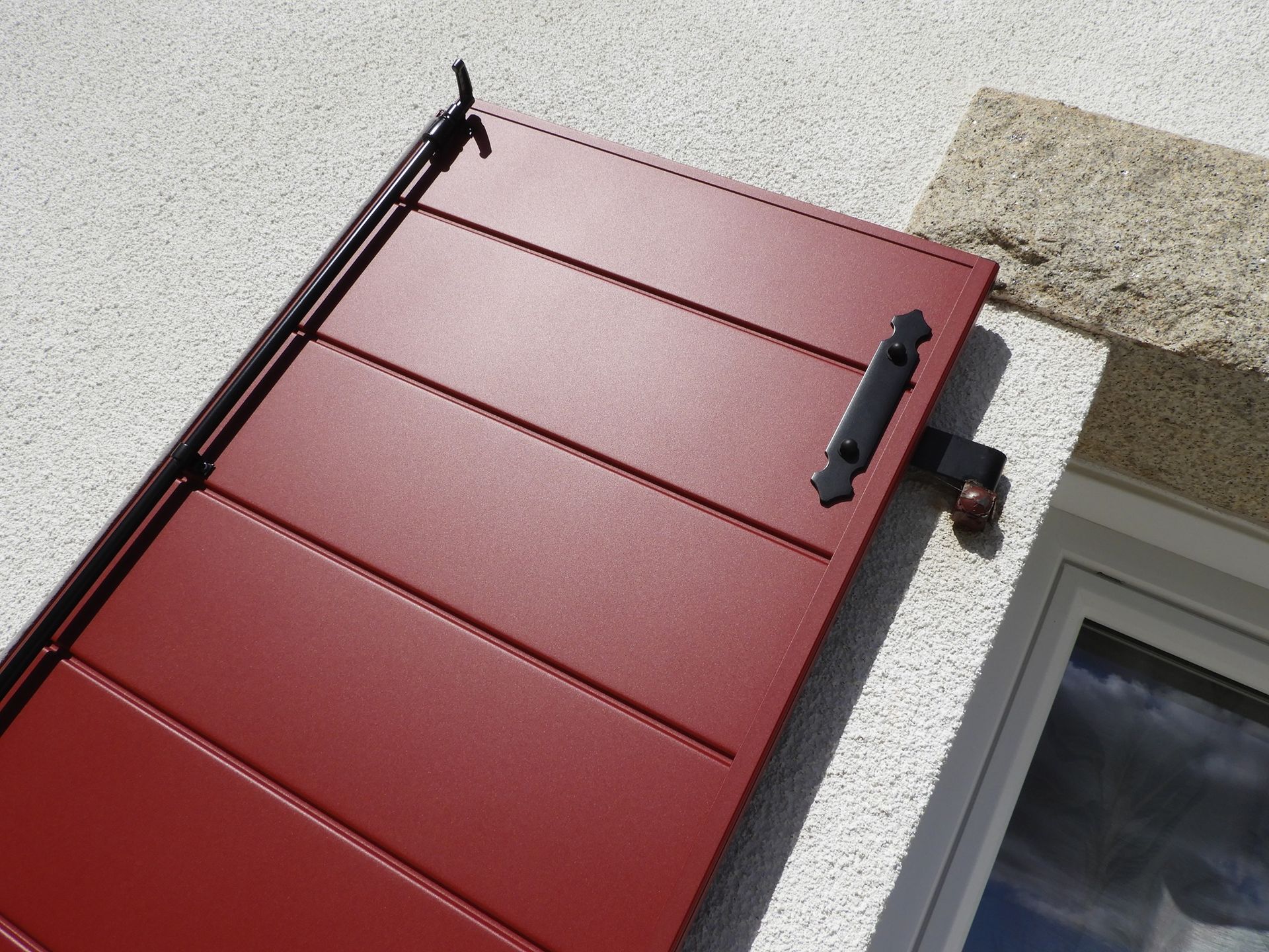 Volet battant rouge avec des lames larges