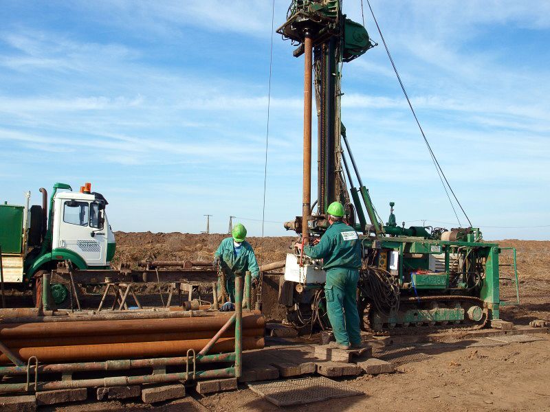 Eine Gruppe Männer arbeitet an einer Maschine auf einem Feld - IBOTECH Bohr- und Brunnenbau GmbH aus Zöberitz bei Landsberg