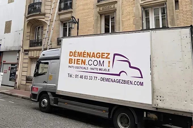 Camion de déménagement portant le logo Déménagez bien devant un immeuble de type haussmannien