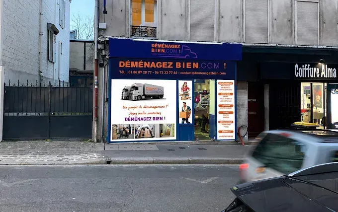 Façade bleue et vitrine de la société Déménagez bien et une voiture qui passe devant