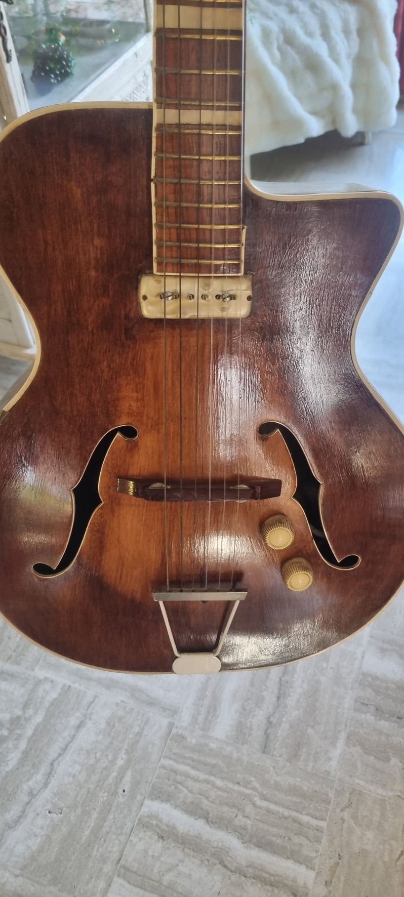 Guitare électrique marron à caisse creuse avec ouïes en forme de f.