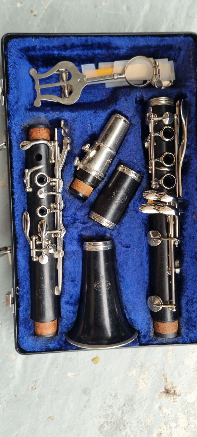 Clarinette noire dans un étui bleu, démontée. Comprend un bec, un barillet et un pavillon.