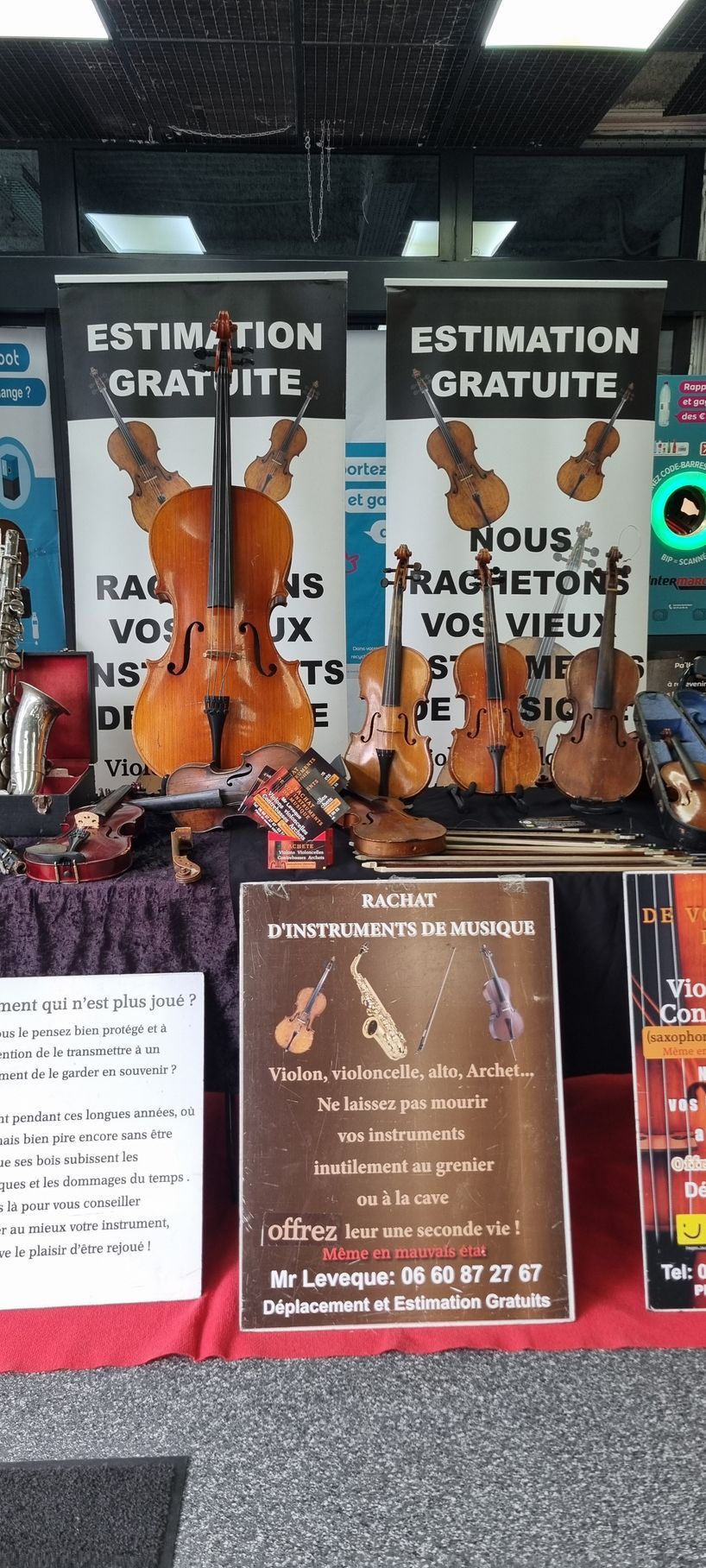 Vitrine présentant des violons, des panneaux indiquant les devis gratuits et les coordonnées du magasin.