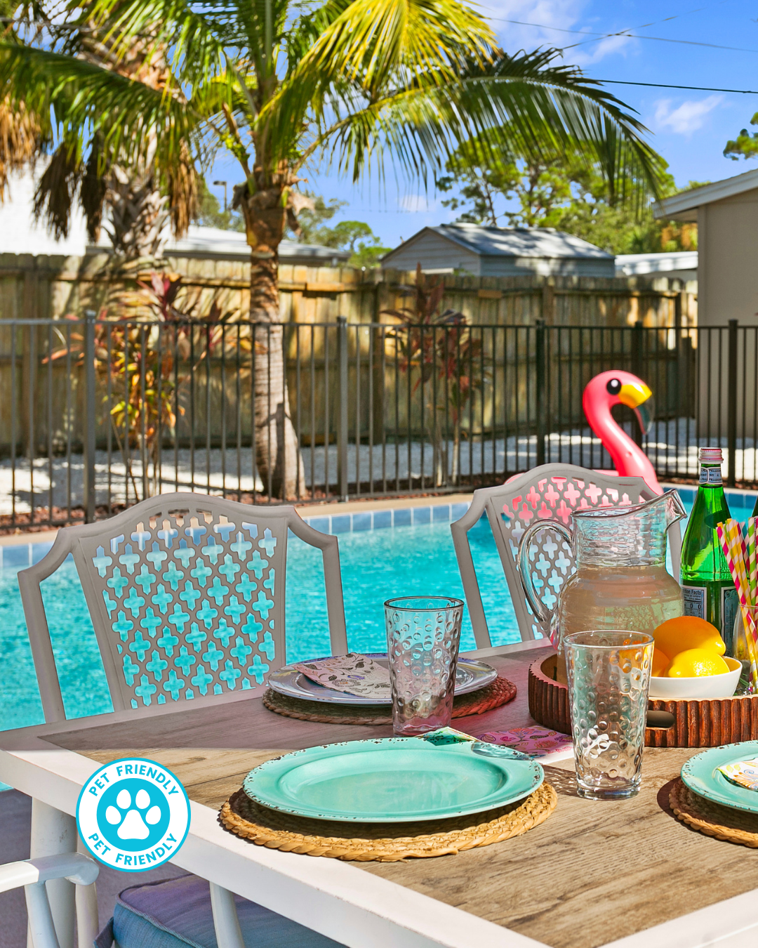 Swimming pool with lounge chairs, red umbrella, and pink flamingo floatie.