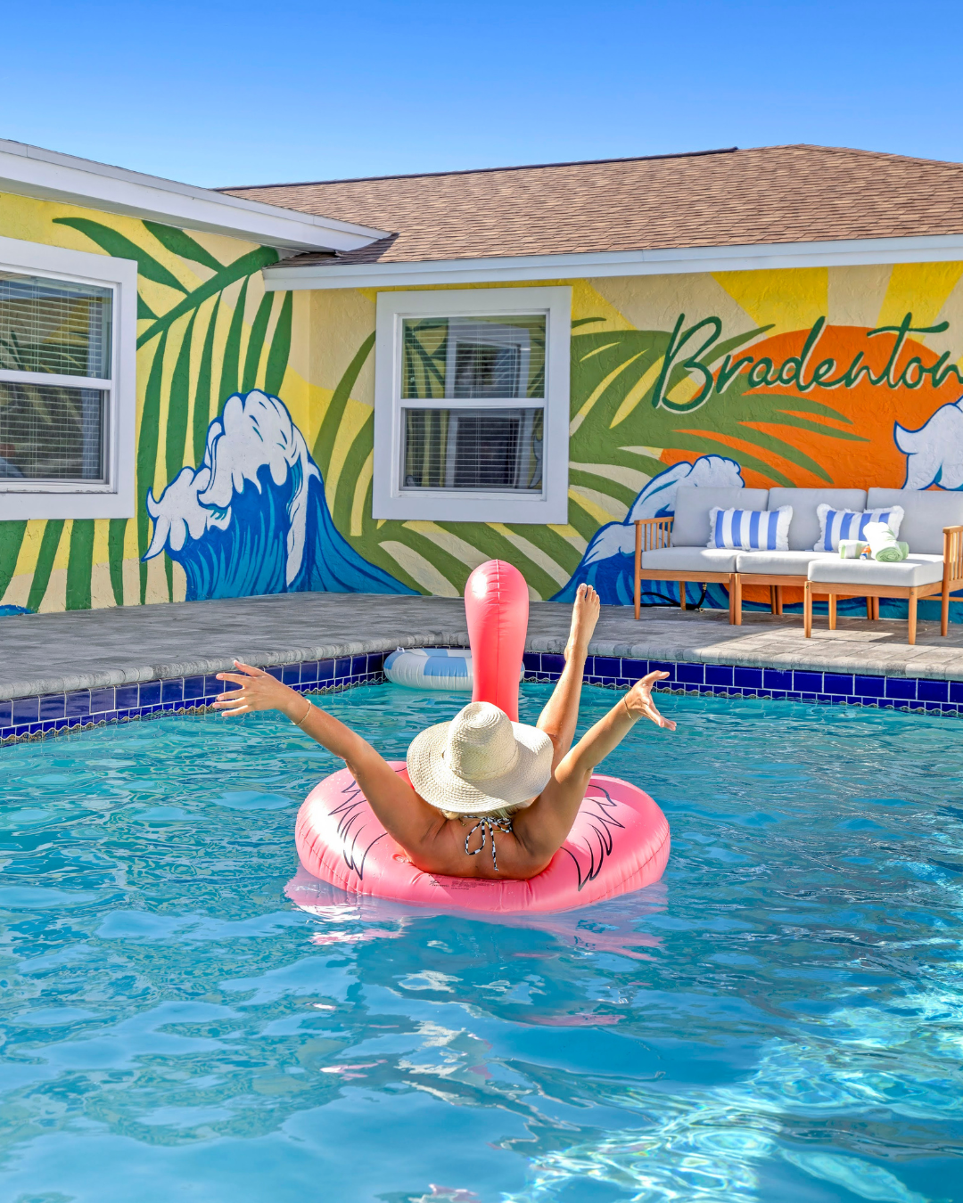 Vacation vibe: pool, flamingo float, and Bradenton wall art.