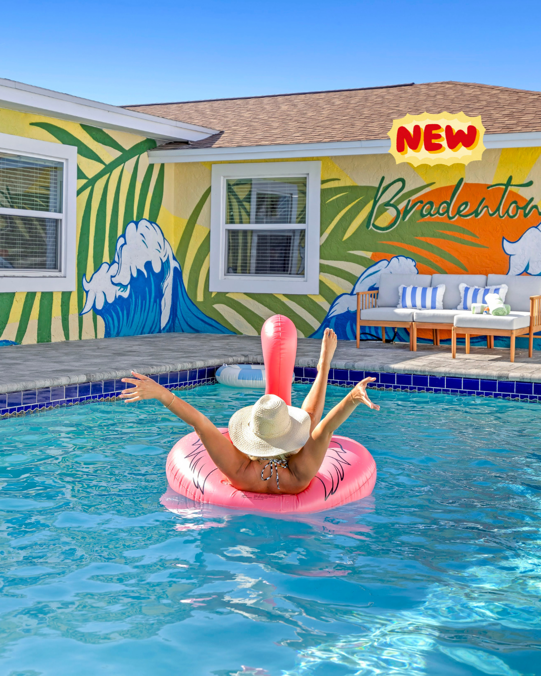 Vacation vibe: pool, flamingo float, and Bradenton wall art.